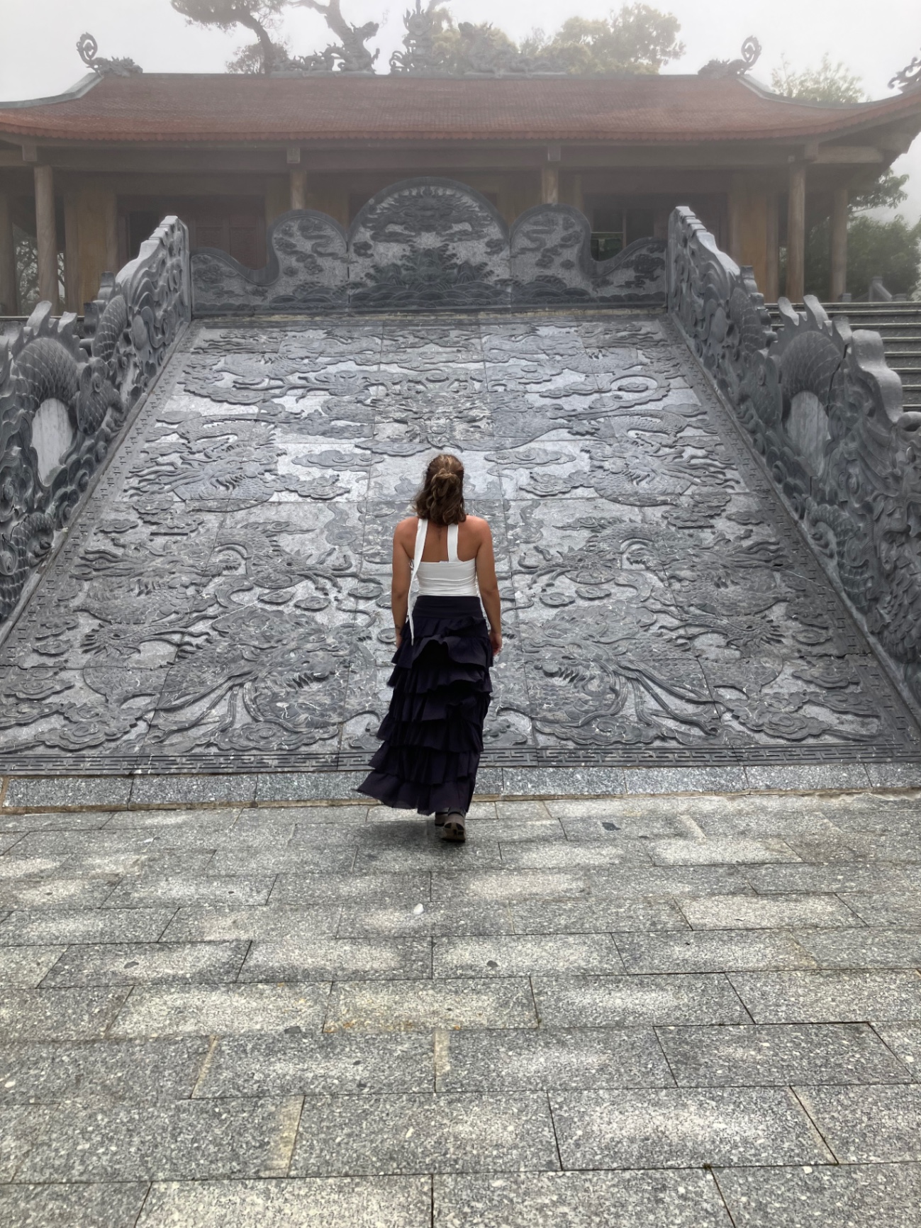 Woman walking toward a mist covered temple